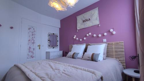 een slaapkamer met een groot bed met paarse muren bij Pause Bayeux in Bayeux