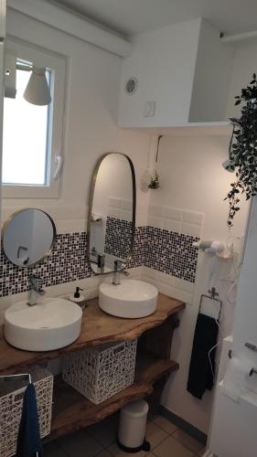 een badkamer met twee wastafels en een spiegel bij Pause Bayeux in Bayeux