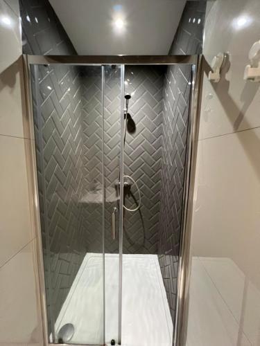a shower with a glass door in a bathroom at Lovely Home in Kimmage, Dublin in Dublin