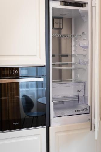 a refrigerator with its door open with a chair in it at PoshSpot Apartments in Cluj-Napoca