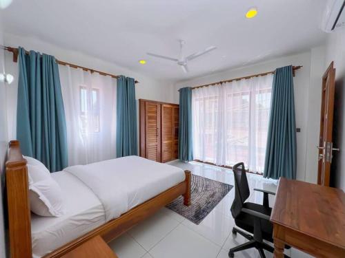 a bedroom with a bed and a desk and a table at Seaside Bliss Vipingo in Tezo