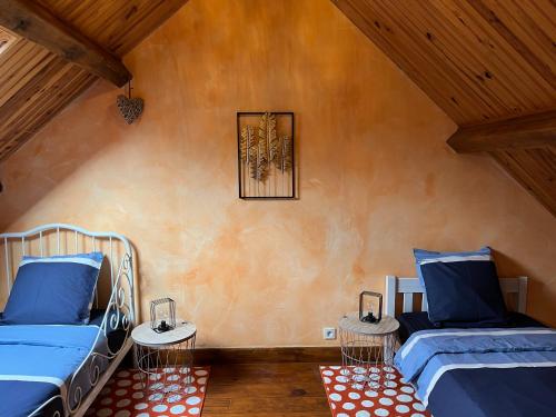 - une chambre avec 2 lits dans une chambre dotée de plafonds en bois dans l'établissement Maison. Neung sur Beuvron. L’Orchidée, à Neung-sur-Beuvron