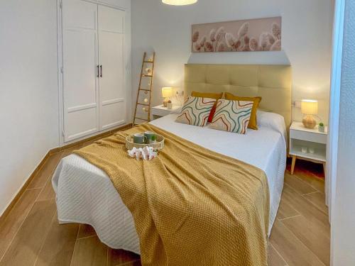 une chambre avec un lit avec une couverture jaune dans l'établissement Apartamento puerto Javea vistalmar, à Jávea
