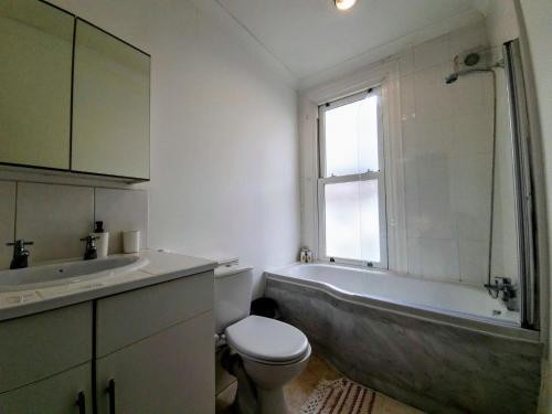 ein Badezimmer mit einer Badewanne, einem WC und einem Waschbecken in der Unterkunft Spacious 4 bedroom house in Brighton & Hove