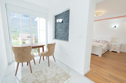 a dining room with a table and chairs and a bedroom at Ema Apartments in Plav