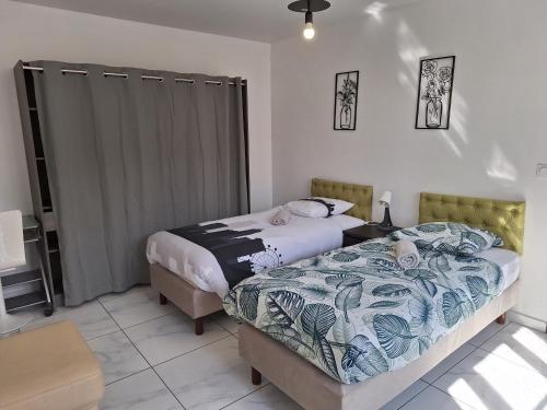 - une chambre avec deux lits et une table avec un couvre-lit dans l'établissement Hypercentre Orléans Carmes, à Orléans