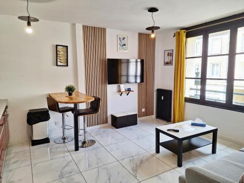 un salon avec une table et un canapé dans l'établissement Hypercentre Orléans Carmes, à Orléans