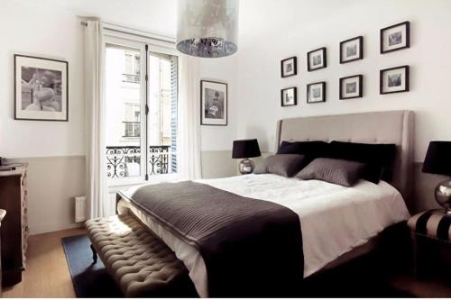 - une chambre avec un grand lit et des photos sur le mur dans l'établissement 205sm luxury and design flat at Paris Montmartre, à Paris