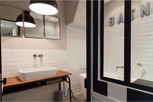 une salle de bain blanche avec un lavabo et un miroir dans l'établissement 205sm luxury and design flat at Paris Montmartre, à Paris