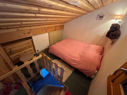 um pequeno quarto com uma cama e uma escada em Bel appartement au décor Montagnard - 80m2 em Les Contamines-Montjoie