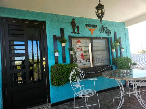 een huis met een blauwe muur met een tafel en stoelen bij Departamento un salto a la frontera in Piedras Negras