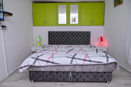 a bedroom with a bed and green cabinets at Kuća Cvetković in Pirot