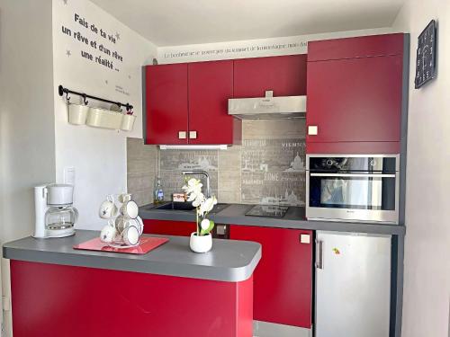 une cuisine avec des armoires rouges et un comptoir dans l'établissement Joli studio avec balcon proche plage - Parking inclus - FR-1-646-9, à Berck-sur-Mer