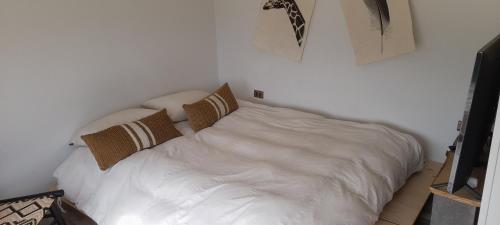 - un lit blanc avec des oreillers dans la chambre dans l'établissement FRENTE AL MAR SUN & WAVES atardeceres mágicos, à Algarrobo