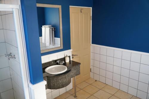 uma casa de banho com um lavatório e um espelho em Pinnacle Point Golf Estate Lodge 78 em Mossel Bay