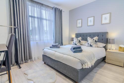 a bedroom with a bed and a large window at Stunning Ensuite Room in Beckenham
