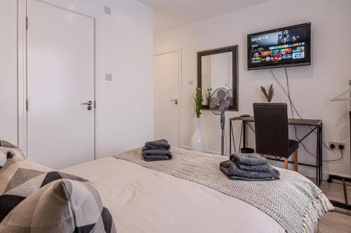 um quarto com uma cama e uma televisão na parede em Stunning Ensuite Room em Beckenham
