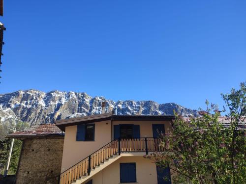 a house with a balcony in front of a mountain at Il Fontanile in Aisone