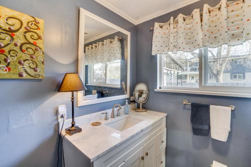 ein Badezimmer mit einem Waschbecken, einer Lampe und zwei Fenstern in der Unterkunft Centennial Home with Hot Tub - 12 Mi to Denver! in Centennial