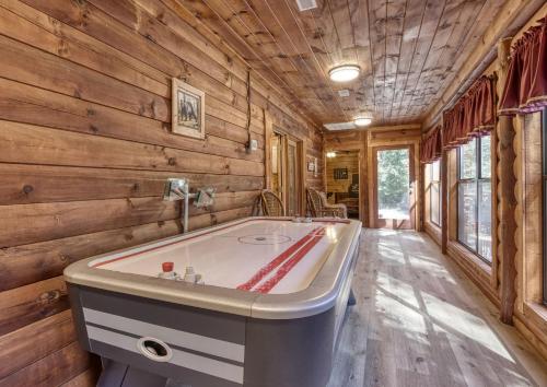 uma grande banheira num quarto com paredes de madeira em Suite Spot #242 em Pigeon Forge