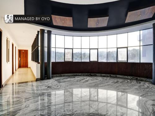 a lobby with a marble floor and windows at OYO Sparrow Suites & Resorts Kattapana in Kattappana