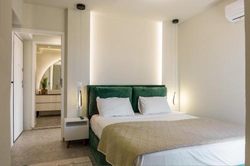 a bedroom with a large bed with a green headboard at S12 Apartments in Heraklio Town