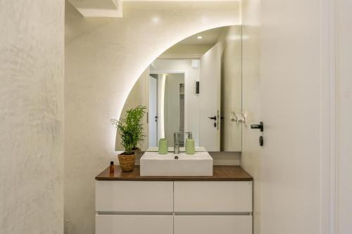 S12 Apartments في مدينة هيراكيلون: حمام مع حوض أبيض ومرآة