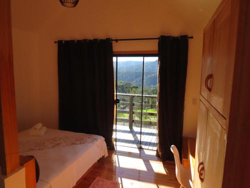 a room with two beds and a window with a view at Refúgio da Montanha in Urubici
