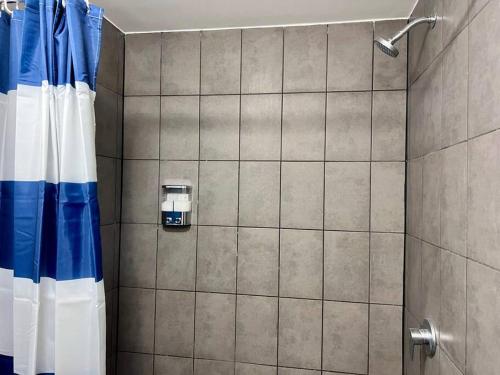 baño con ducha con cortina azul y blanca en Casa 11, en Guatemala