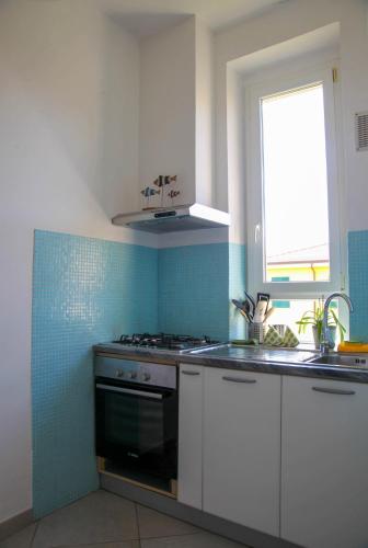 a kitchen with a stove and a sink and a window at CasaA in La Spezia