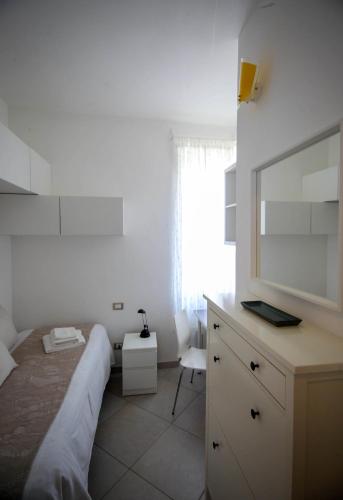 a bedroom with a bed and a dresser with a mirror at CasaA in La Spezia
