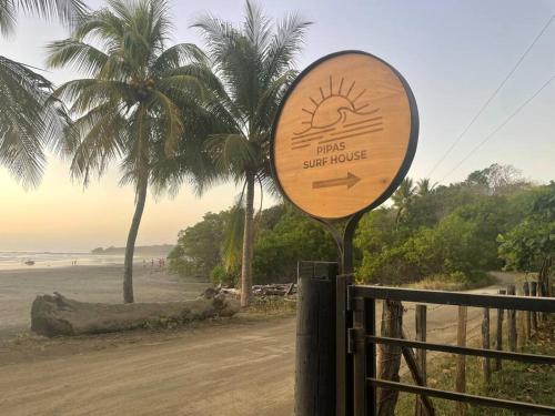 a sign on a fence next to a beach at Pipa's Surf House Marbella Guanacaste in Cuajiniquil