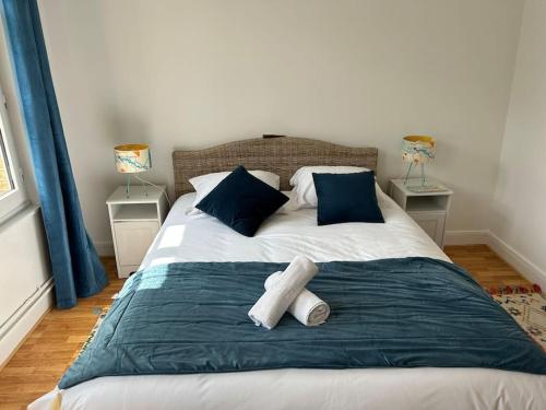 - une chambre avec un lit doté d'oreillers bleus et blancs dans l'établissement Villa Roc Vaudieu - Charmante maison de pêcheurs, à Étretat