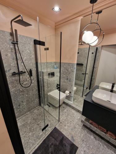 a bathroom with a shower and a toilet and a sink at Apartament G13 Nautica Resort Giżycko in Giżycko
