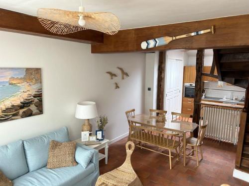 - un salon avec un canapé bleu et une table dans l'établissement Villa Roc Vaudieu - Charmante maison de pêcheurs, à Étretat
