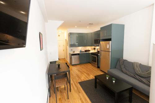 ein Wohnzimmer mit einem Sofa und einer Küche in der Unterkunft Deluxe Studio Apt Close to NYC in Union City