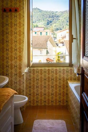a bathroom with a window and a tub and a sink at Appartamento Middle Earth in La Spezia