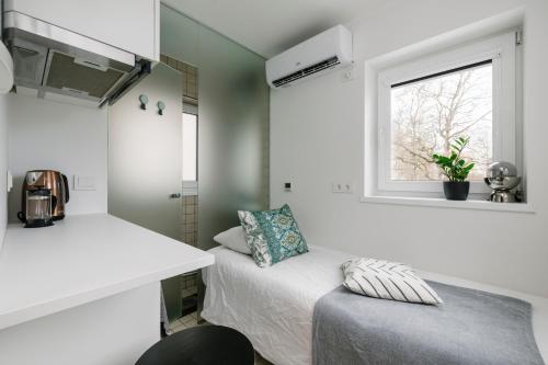 a small bedroom with a bed and a window at Apartment for one - white in Tallinn