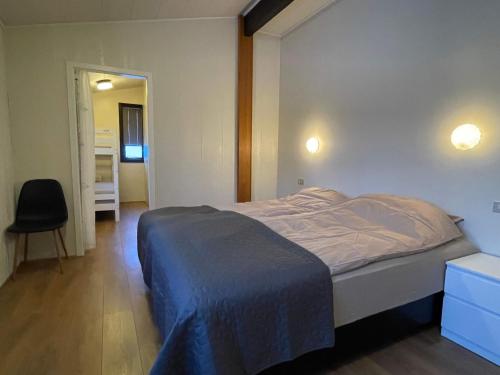 um quarto com uma cama e uma cadeira em Hvolsvollur Central Apartment em Hvolsvöllur