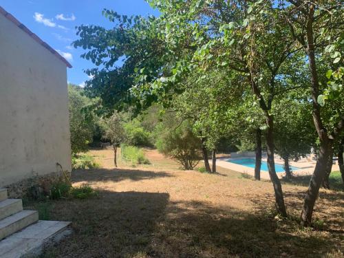 a view of a yard with a pool and trees at Guest House in Montauroux
