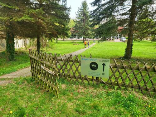 a sign on a wooden fence in a park at Harz Hotel Vogelberg in Blankenburg