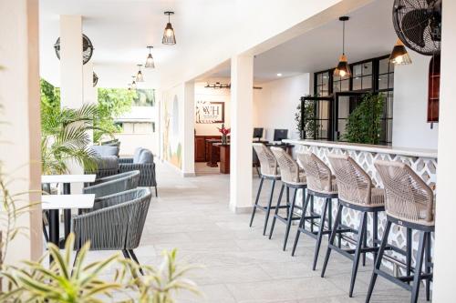 a row of stools at a bar in a restaurant at The West House Boutique Hotel in San Ignacio