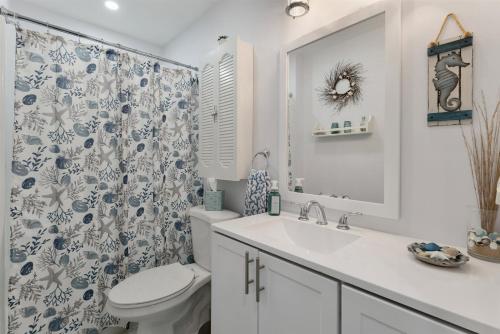 y baño con lavabo, aseo y cortina de ducha. en 5600 Seaview Ave, Unit 15, en Wildwood Crest