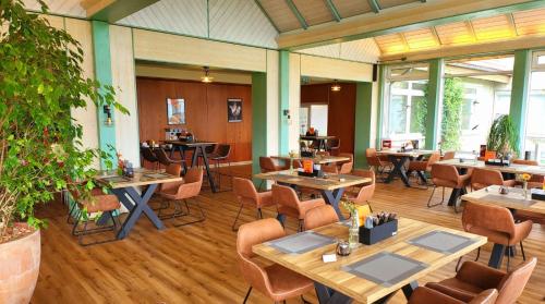 布蘭肯堡的住宿－Harz Hotel Vogelberg，一间在房间内配有桌椅的餐厅