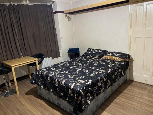 a bedroom with a bed and a table and a window at Leicester UK Fosse Park Shopping Centre Room 2 in Braunstone