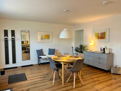 comedor y sala de estar con mesa y sillas en Modernes Studio-Apartment in toller Waldrand-Lage en Kaiserslautern