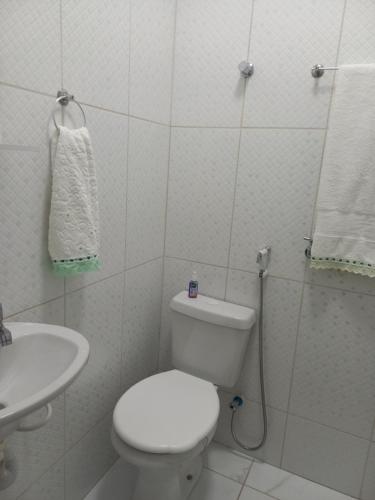 a white bathroom with a toilet and a sink at 1 Quarto Turismo Teresópolis in Teresópolis