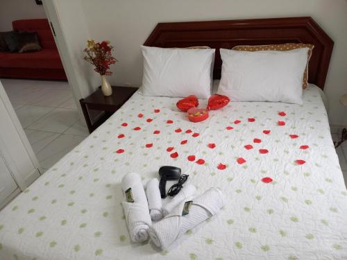 a bed with towels and shoes and roses on it at 1 Quarto Turismo Teresópolis in Teresópolis