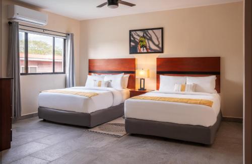 1 dormitorio con 2 camas y ventana en The West House Boutique Hotel en San Ignacio