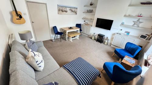 a living room with a couch and a table and a guitar at Heart of DARTMOUTH TOWN CENTER and with own PRIVATE PARKING - These Two Traditional Georgian SUPER STYLISH DUPLEX APARTMENTS are NEWLY REFURBISHED and have a CONNECTING DOOR For Larger Groups!!! in Dartmouth